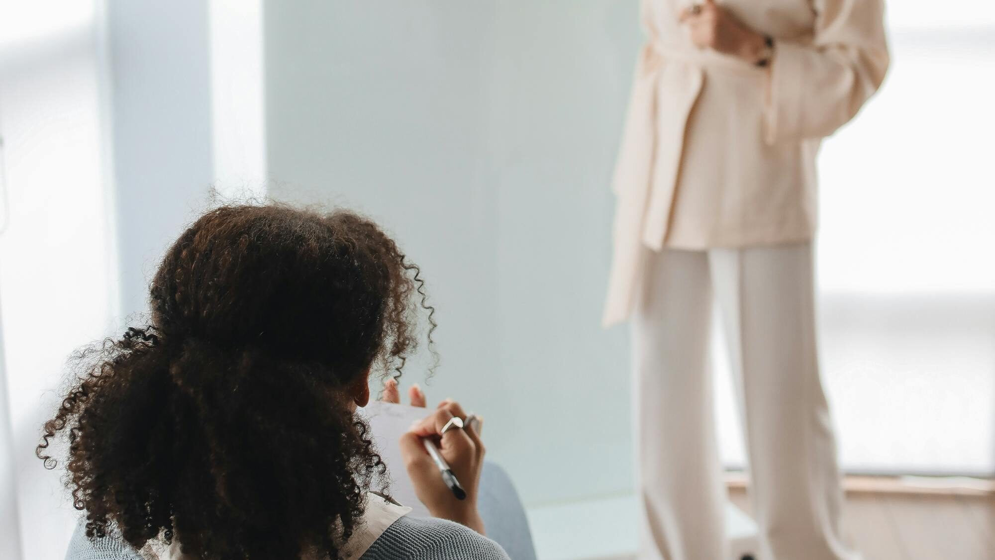 Two women engage in an interactive learning session with a whiteboard in a modern classroom.